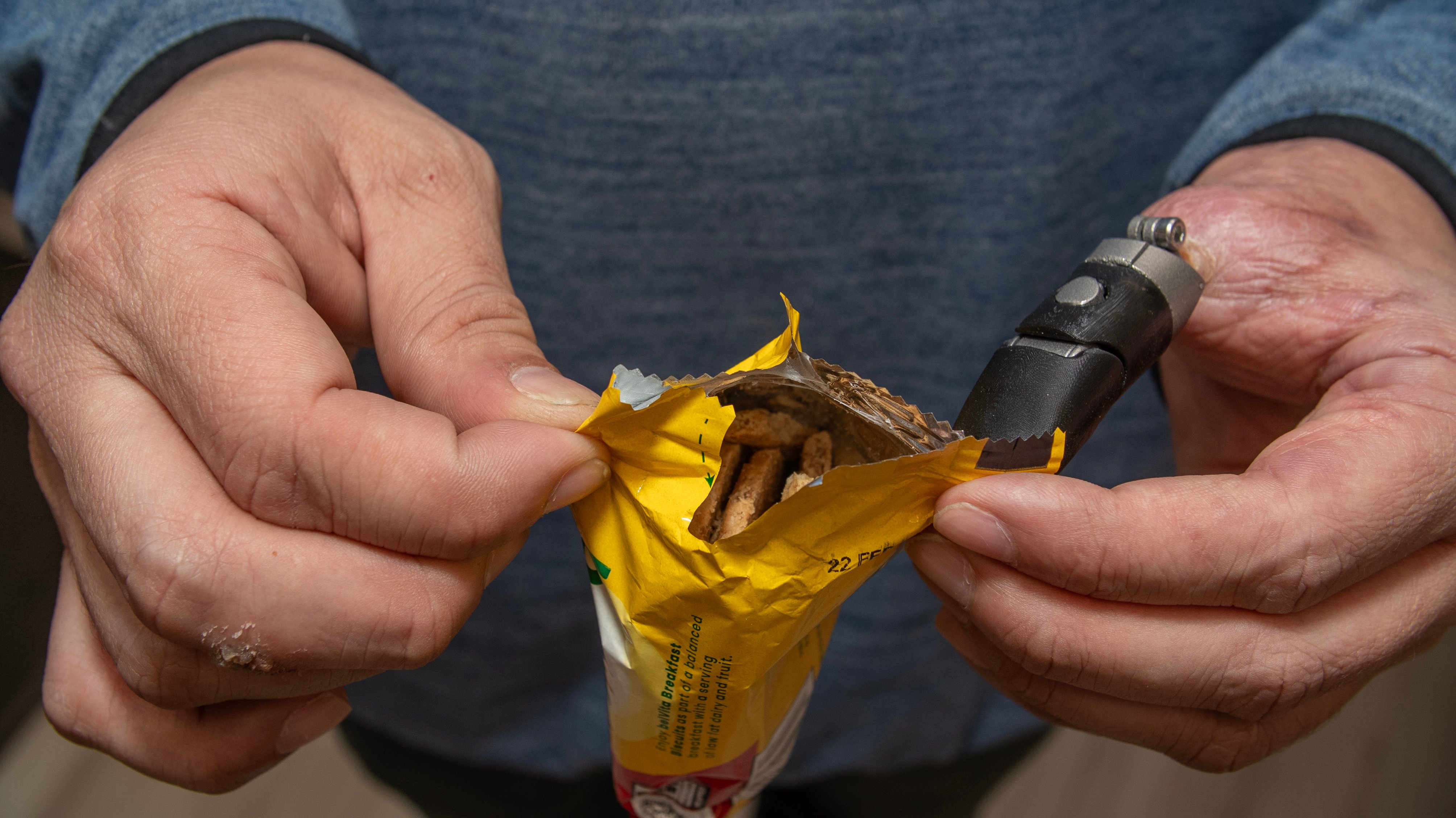 Bone-anchored prosthetic thumb opening a chip bag